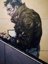 A stylized painting of a person in a dark jacket, leaning forward with clenched hands. The facial expression is intense, featuring exaggerated features like a pronounced mouth and furrowed brow. The background is mostly plain with subtle color contrasts.