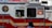 A red and white emergency vehicle with the FDNY HazMat logo and 'Specialists' written on its side. A person is visible inside the vehicle, and there is a pedestrian in the foreground.