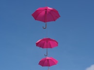 three hanging pink umbrellas