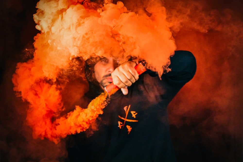 close-up photography of man covered by orange smoke