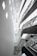 An abstract architectural interior featuring modern design elements with angular lines and bright lighting. The multi-story structure showcases several levels with glass railings and recessed lighting, conveying a sense of space and openness.