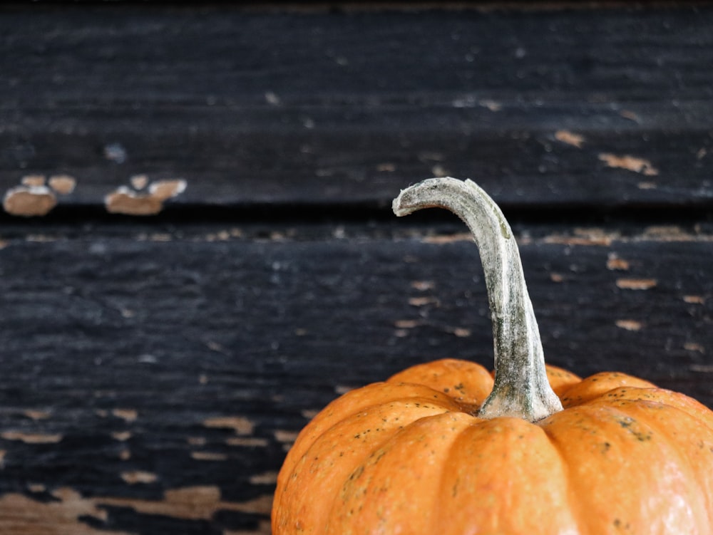 una piccola zucca seduta sopra un tavolo di legno