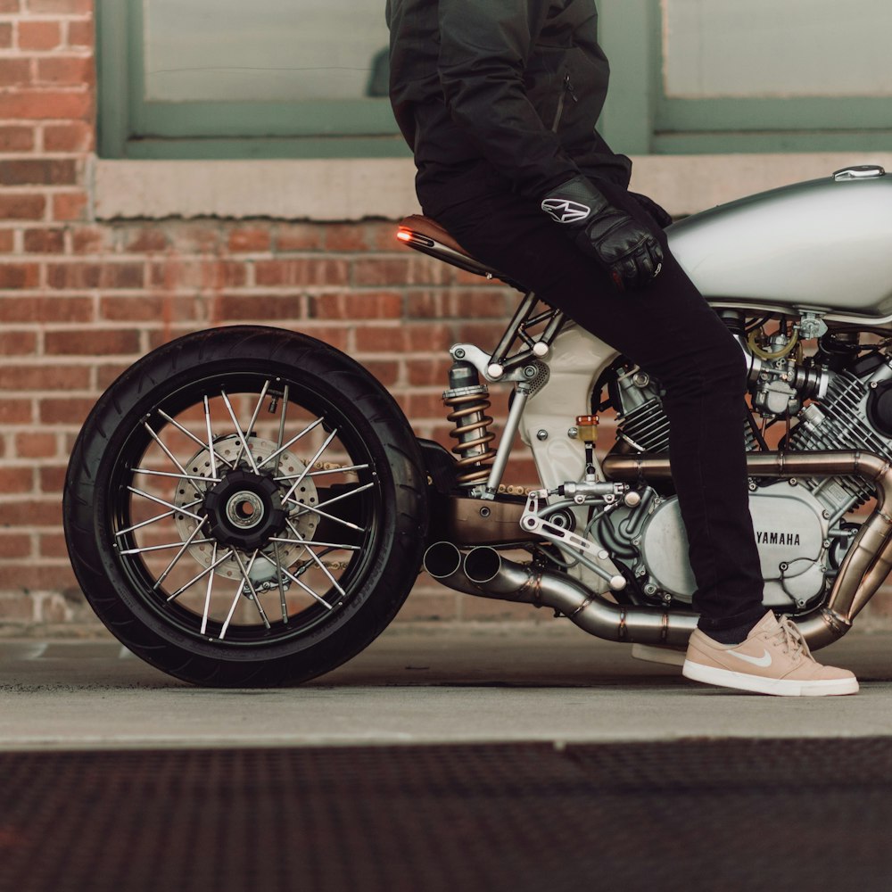 man riding a motorcycle on a sidewalk