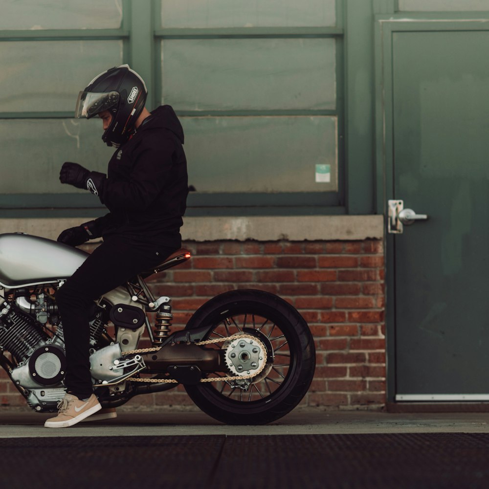 man riding a motorcycle on side of the road