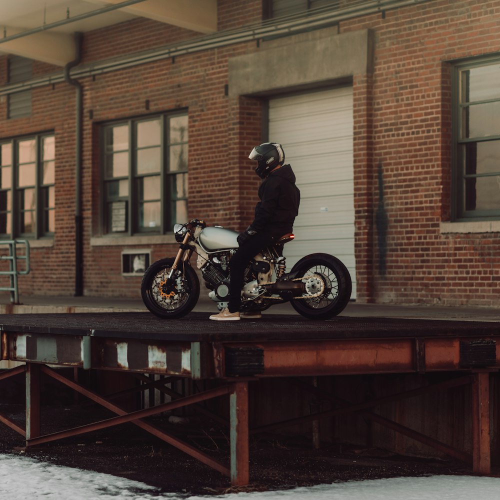 man riding on motorcycle outside house