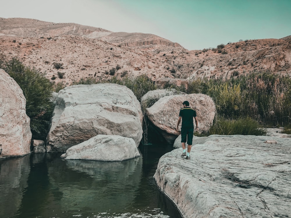 person standing on gray rock