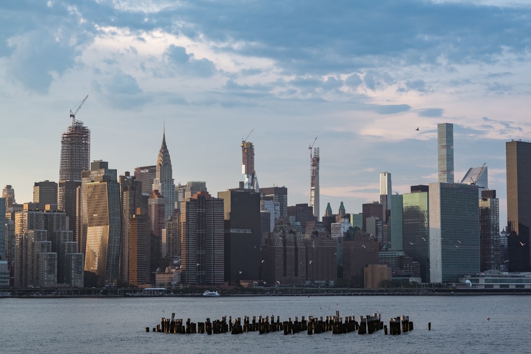 a large body of water with a city in the background, Manhattan by day