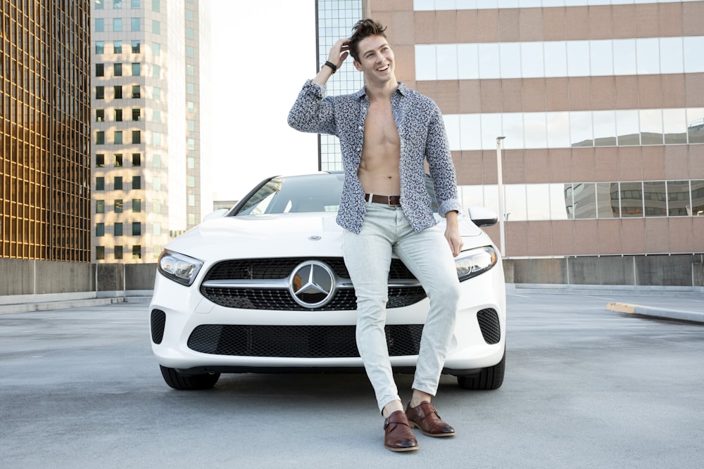 smiling man standing near white Mercedes-Benz car