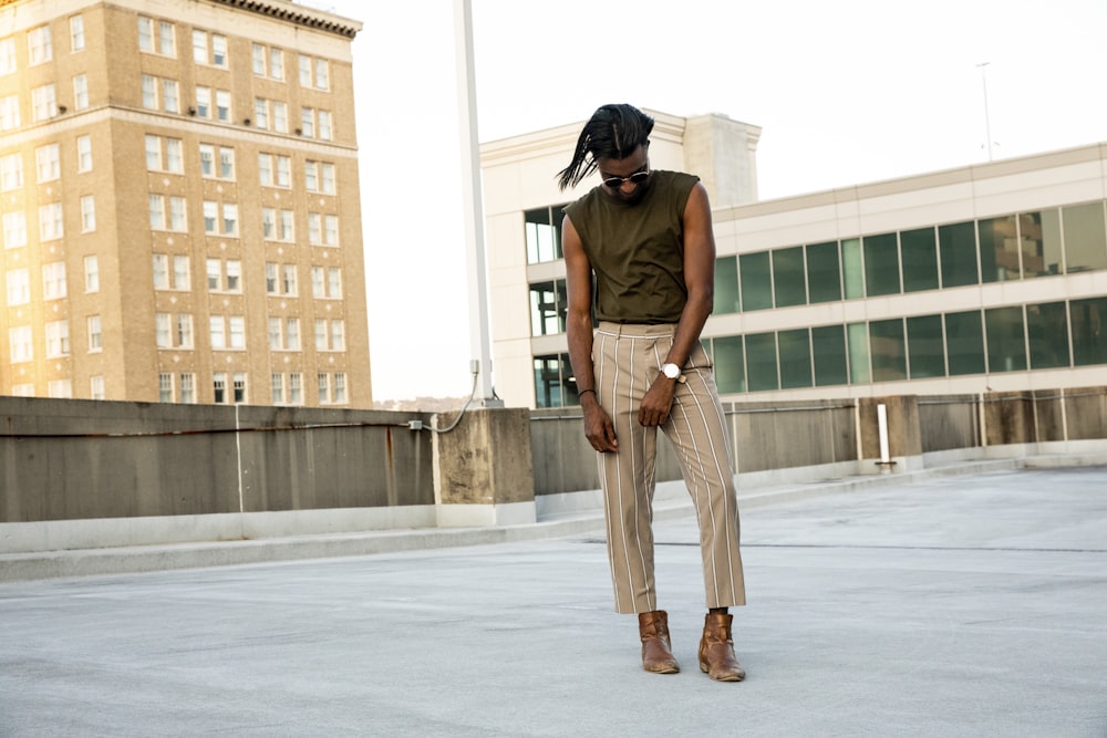 standing man wearing brown sleeveless shirt