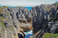 a rocky cliff with a body of water in the middle of it