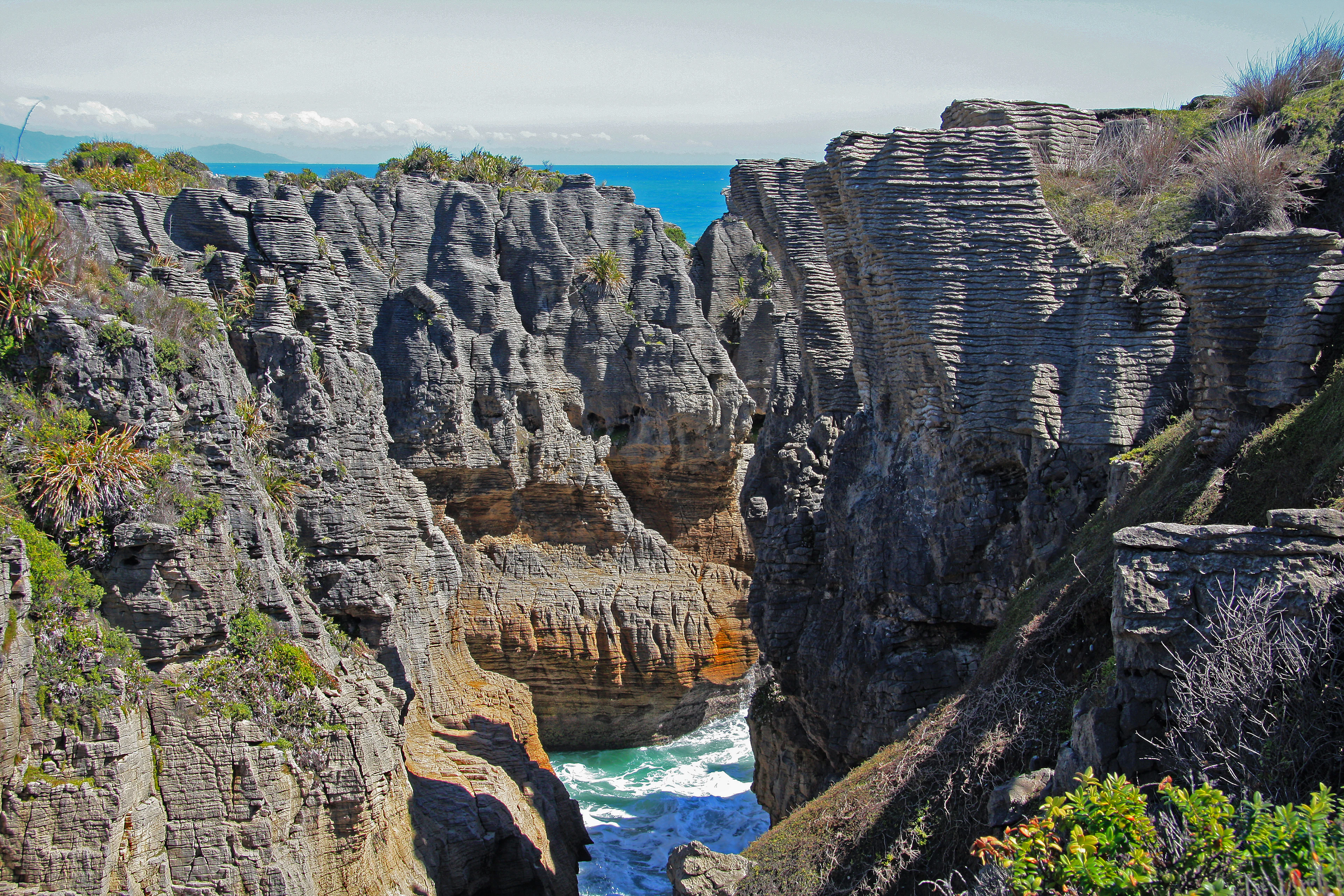 The layered Pancake Rocks and the surf between them at Punakaiki, West Coast