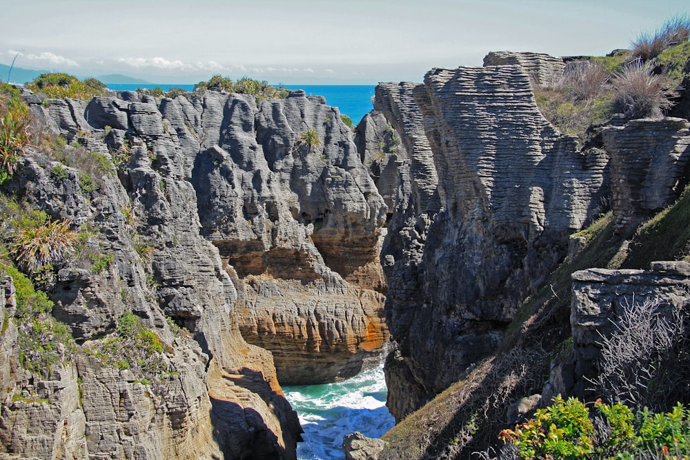 a rocky cliff with a body of water in the middle of it