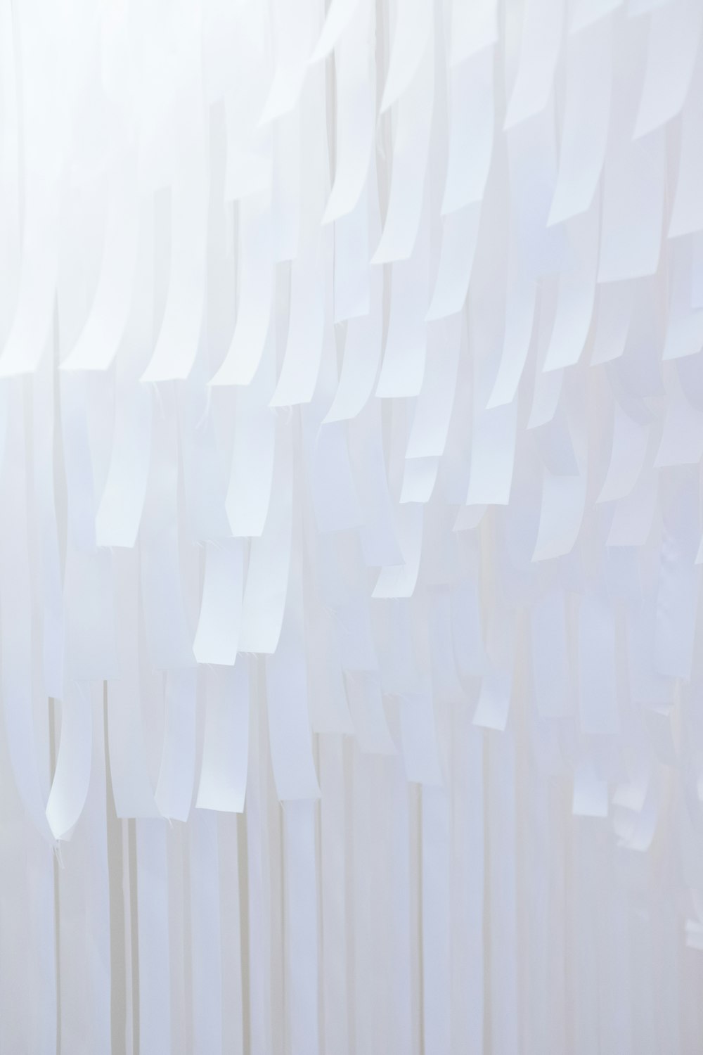 a white wall that has a bunch of strips of paper on it