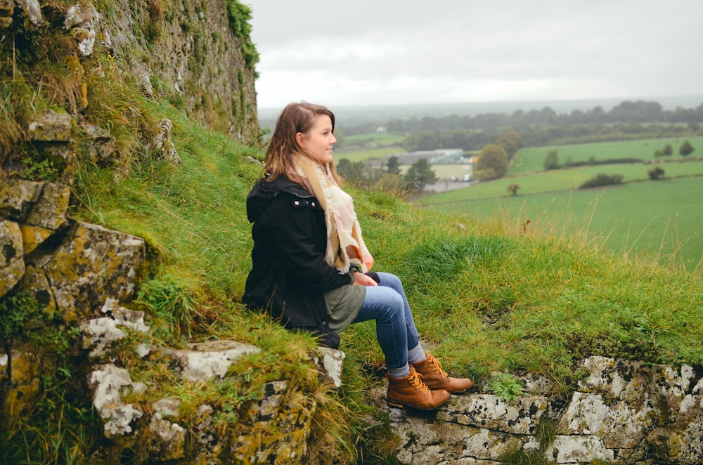 woman sitting on rock