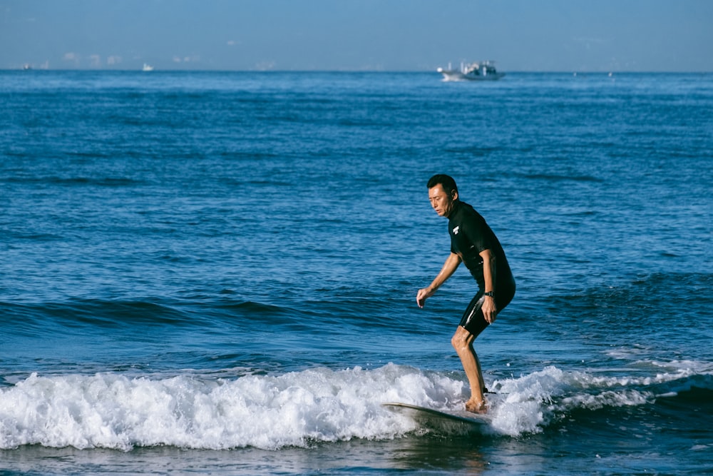 man riding surfboard under blue sky