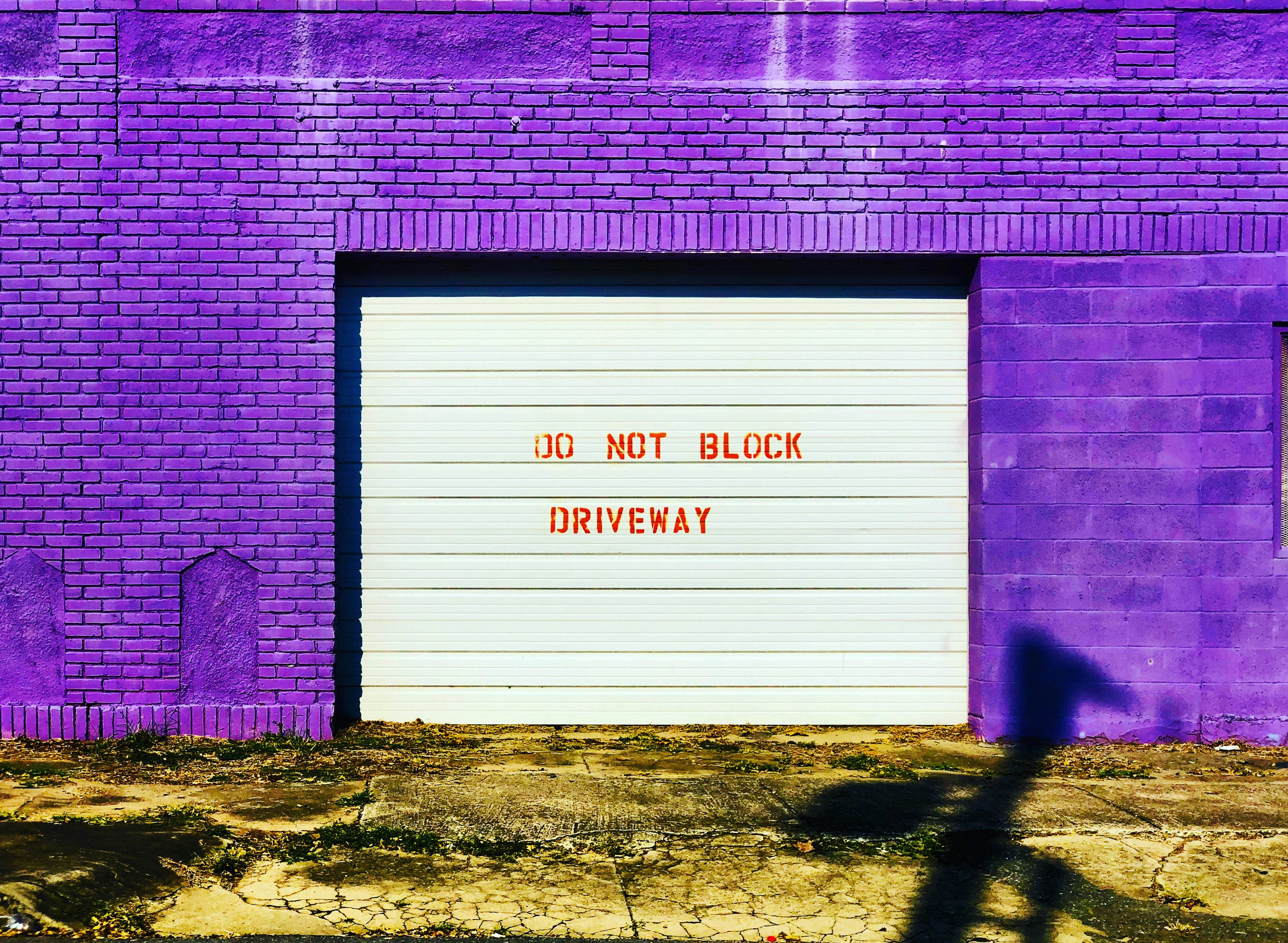 a purple brick building with a white garage door