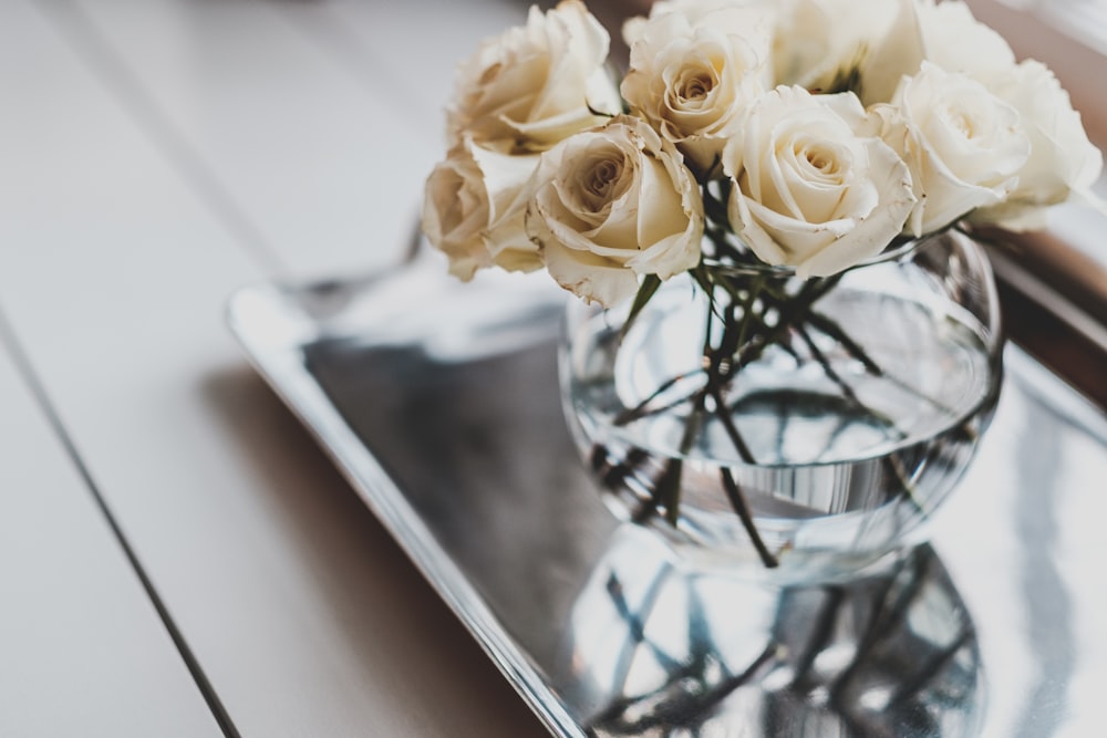white rose arrangement on glass vase