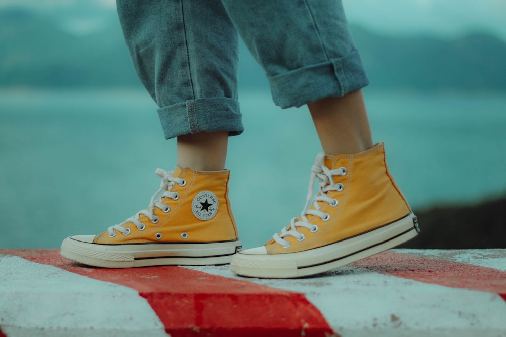 person wears yellow orange Converse All-Star high-top sneakers photo – Free  Vietnam Image on Unsplash