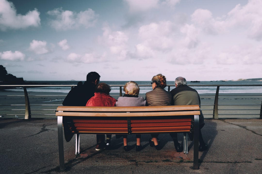 five person sitting on red wooden bench