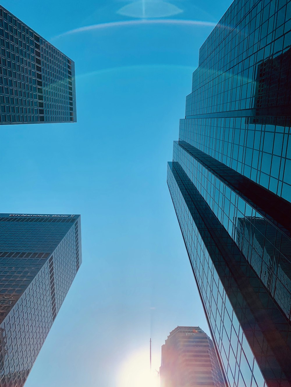 mirror high rise buildings during daytime