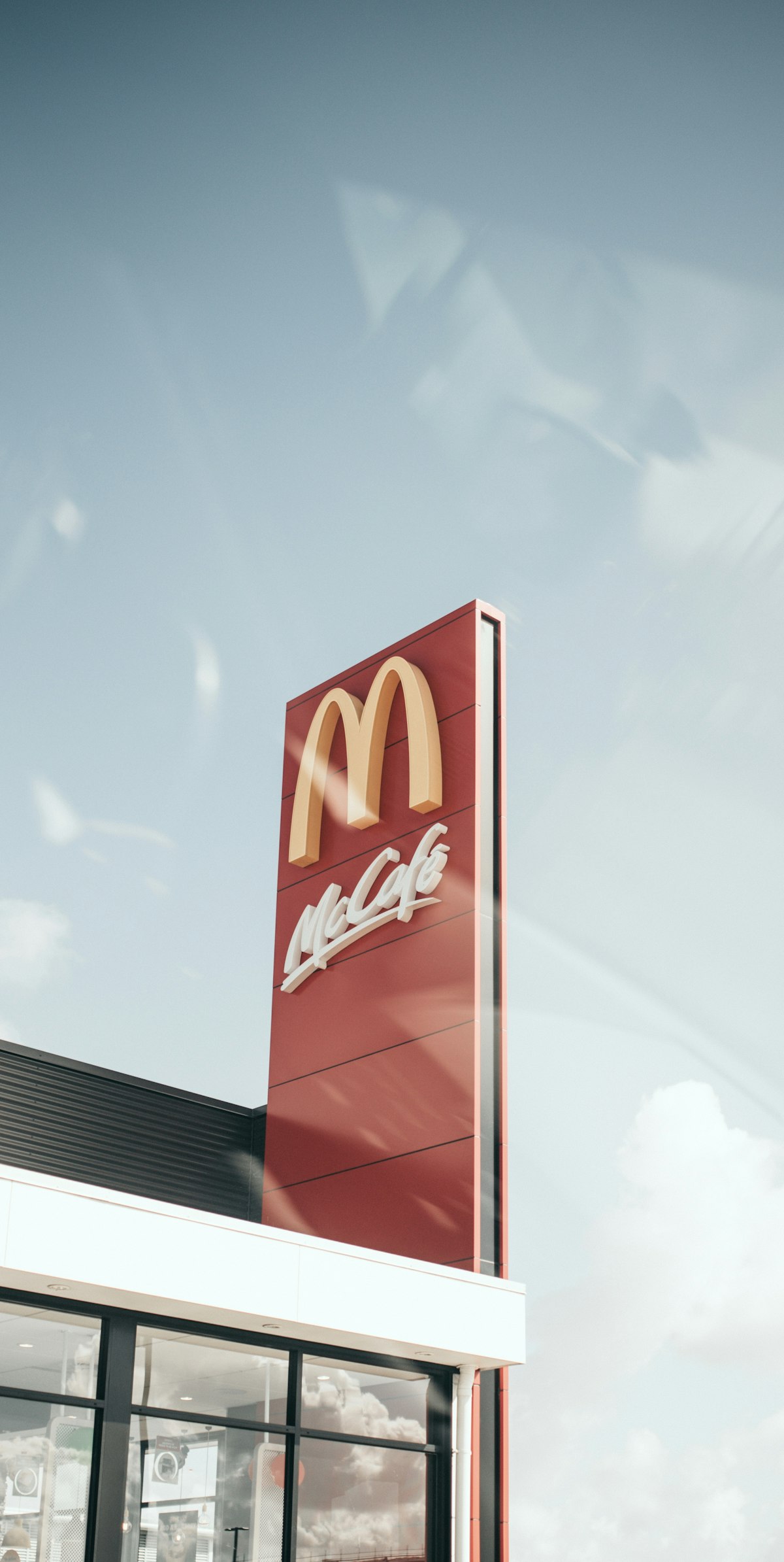 A McDonald's restaurant exterior with golden arches against a blue sky