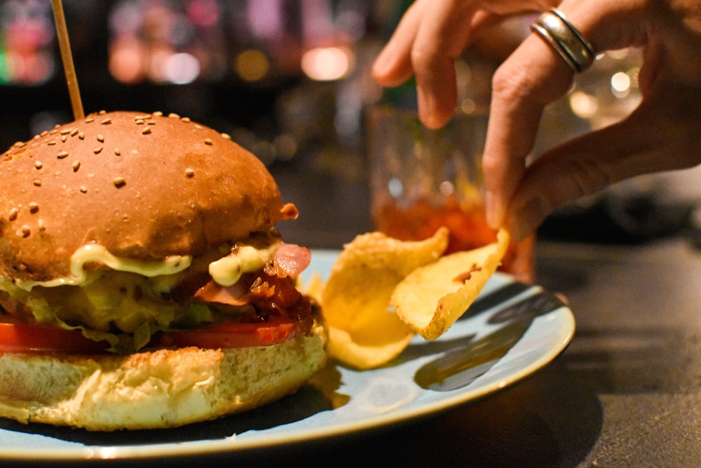 burger beside chips on plate