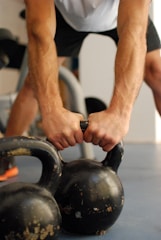 Close-up of a person’s hands gripping a kettlebell during a workout.