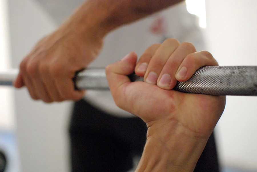 Hands gripping a barbell mid-lift inside ThinkFit Studio
