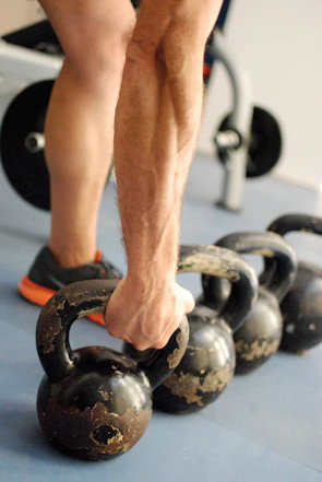 person holding black kettlebell