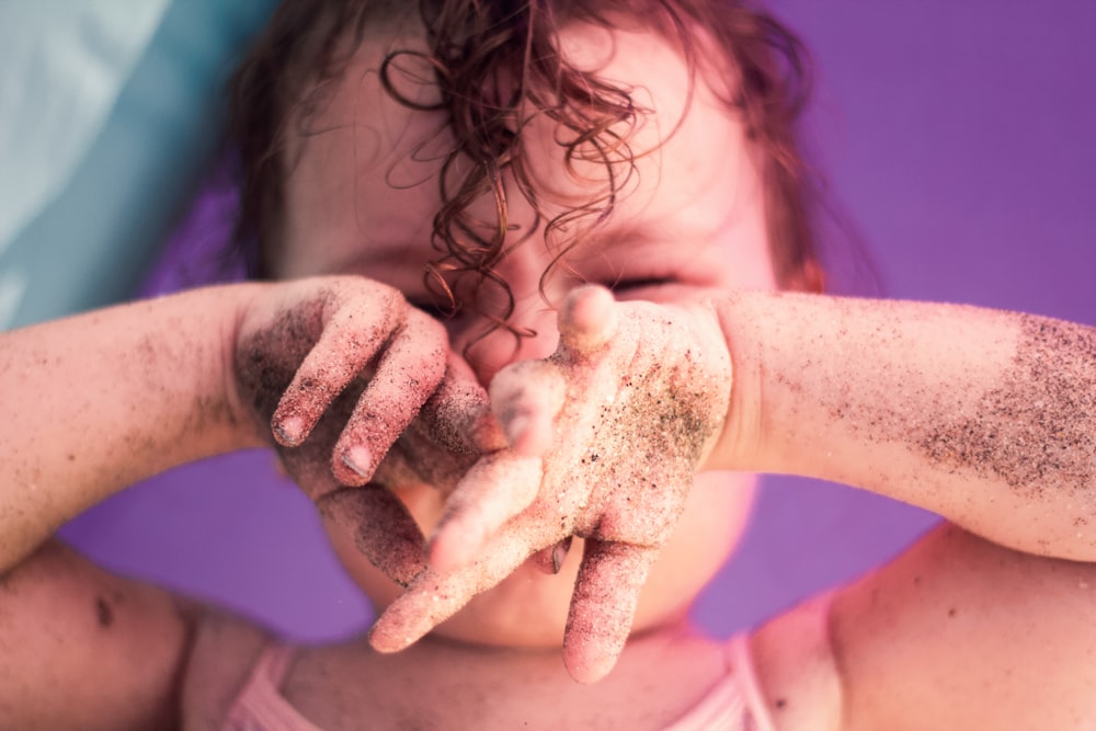 Baby mit schwarzem Sand auf der Hand