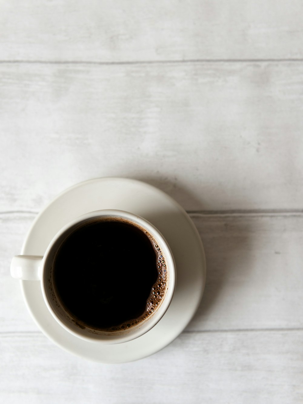 Draufsicht auf weiße Keramik-Teetasse mit Kaffee