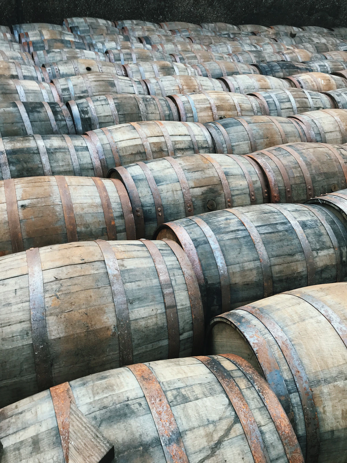 Stacked whiskey barrels inside a warehouse