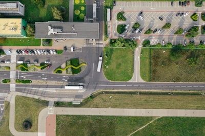 vehicles on road and parked on parking lot during day