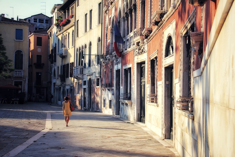 woman walking on sidewalk near building