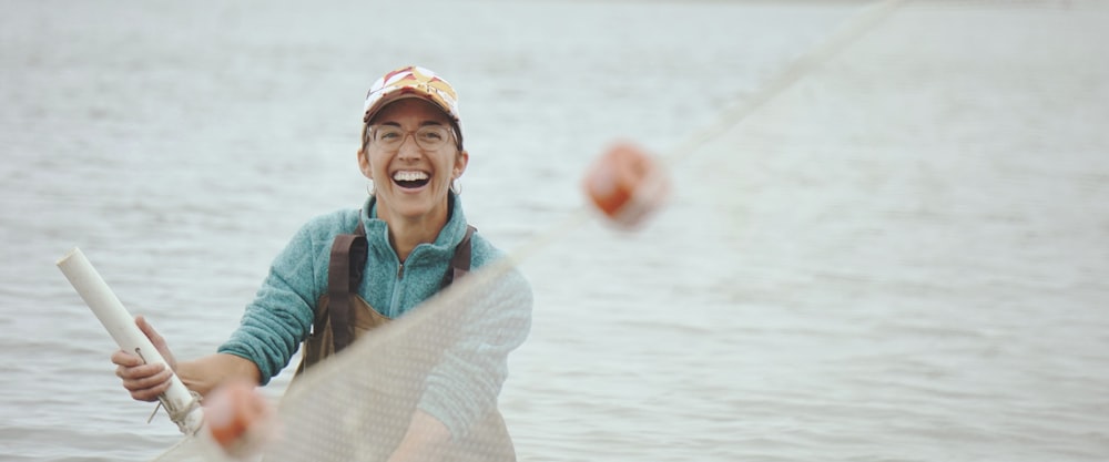 a man in a hat is throwing balls in the water