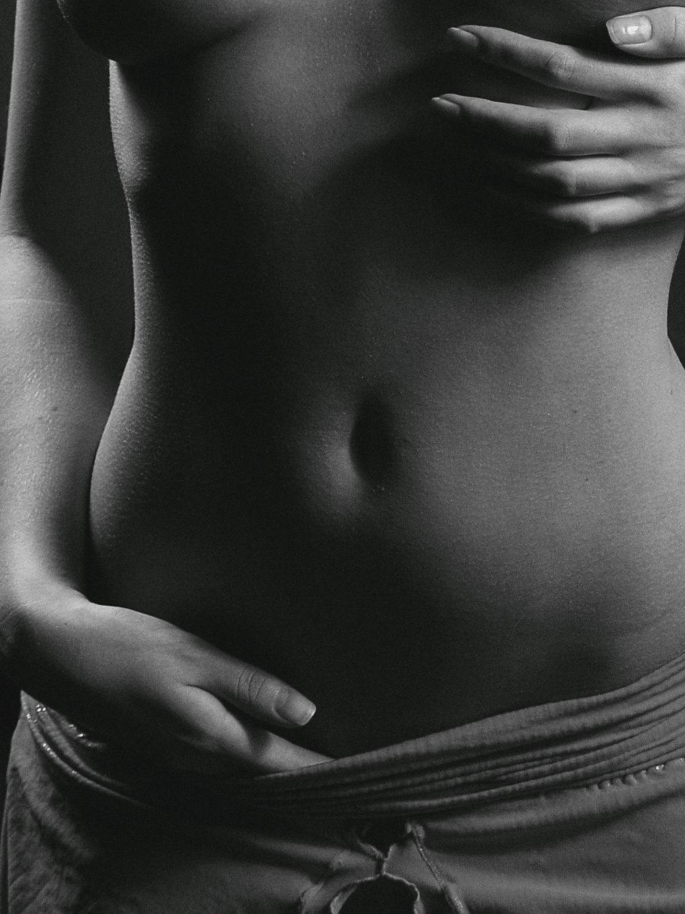ein Schwarz-Weiß-Foto des Bauches einer Frau