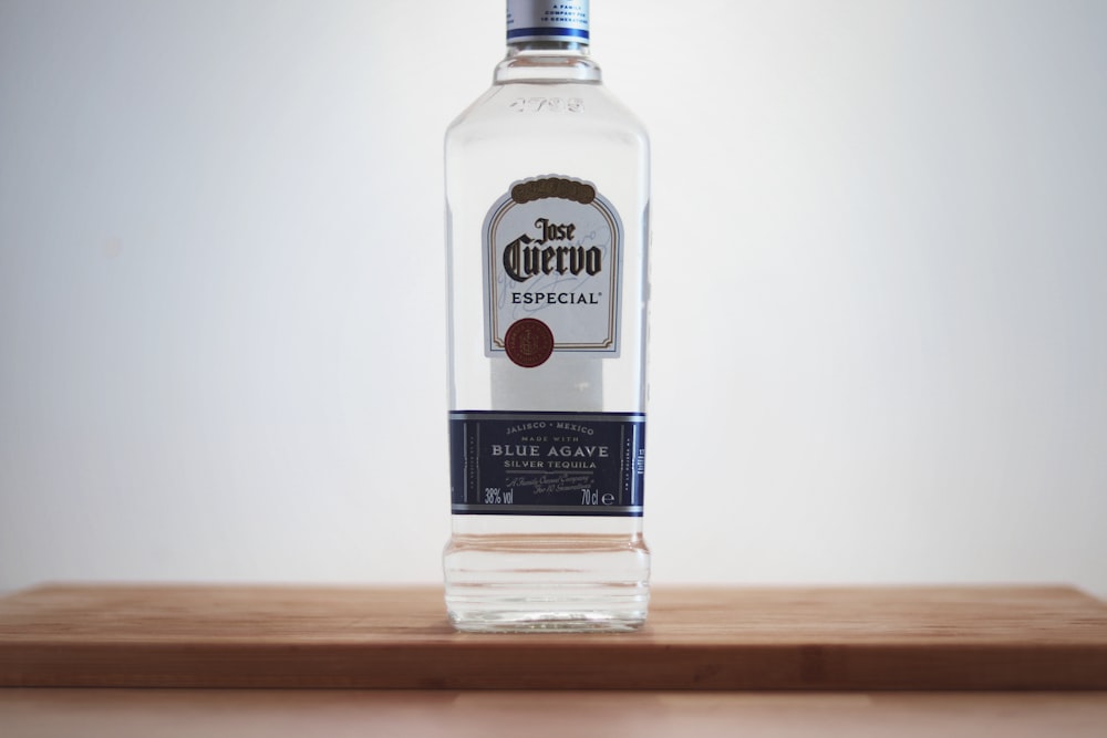 Cuervo glass bottle on brown wooden surface