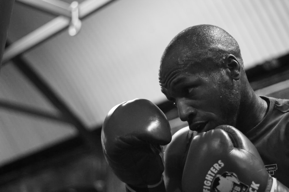 grayscale photo of man wearing boxing gloves