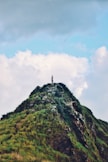 person standing on grass mountain during day