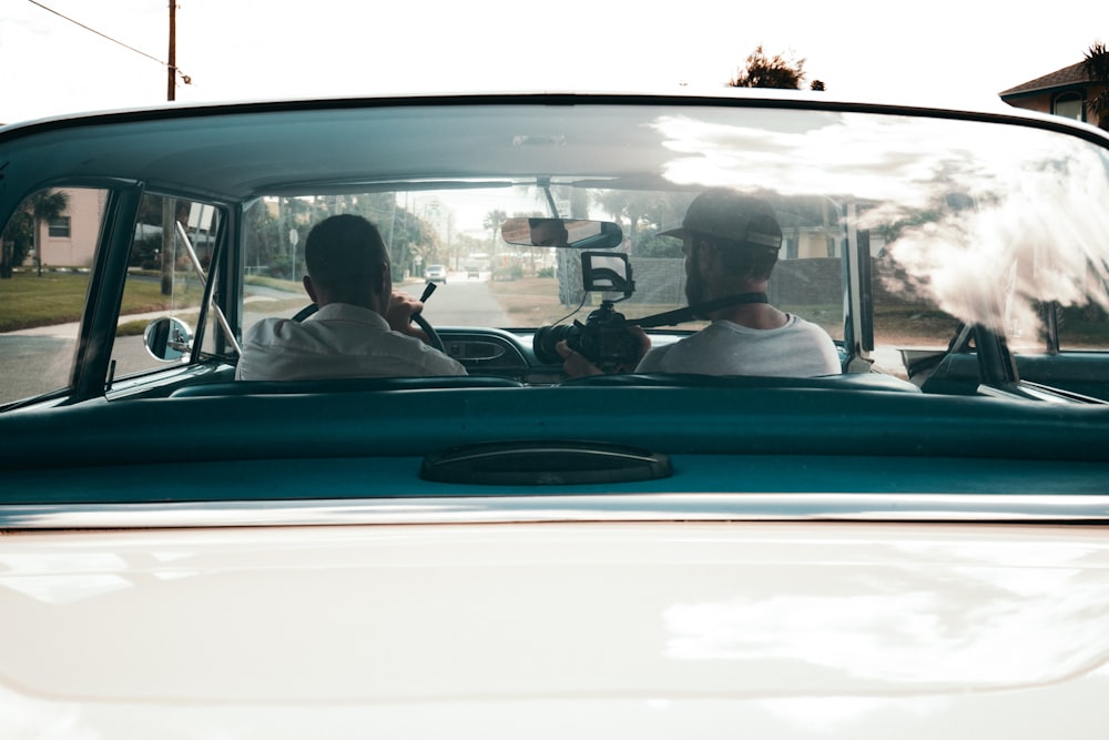 two men sitting in vehicles