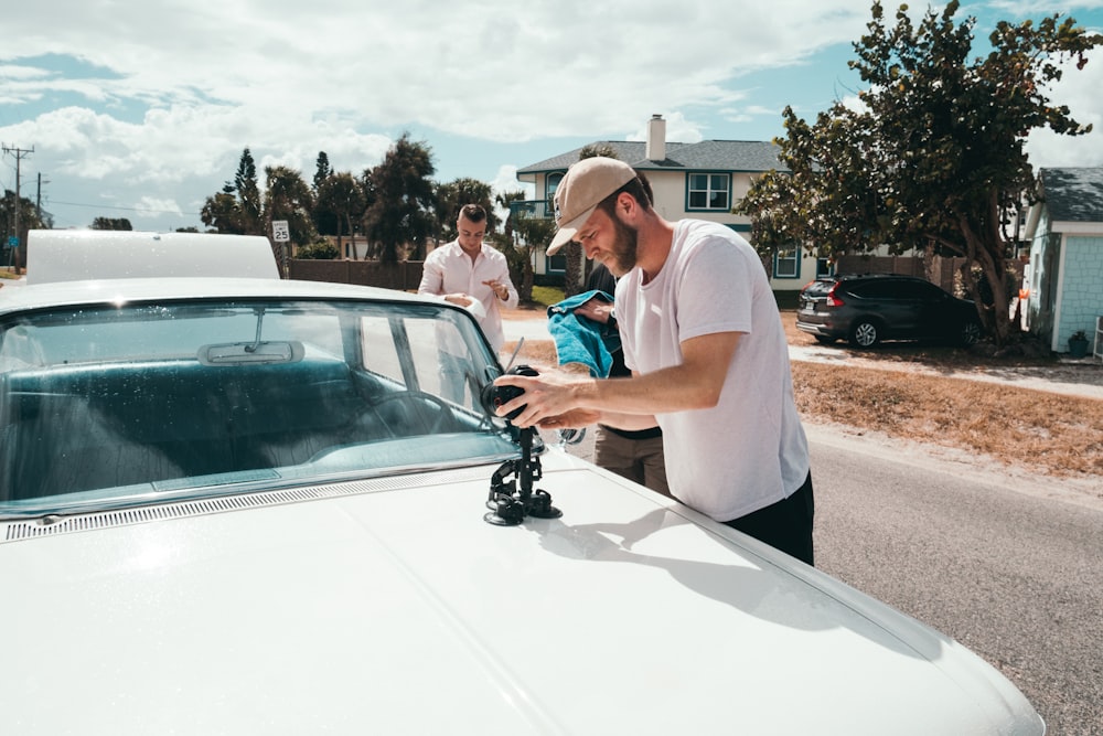 man holding camera on white car