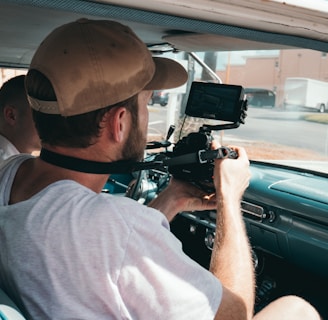 man sitting in vehicle while using camera