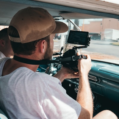 man sitting in vehicle while using camera