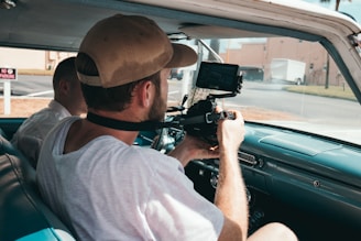 man sitting in vehicle while using camera