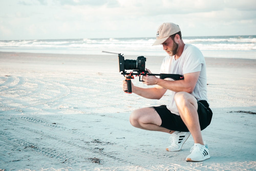 man holding camera on shore