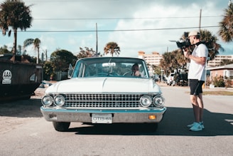 man standing beside white vehicle