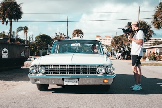 man standing beside white vehicle
