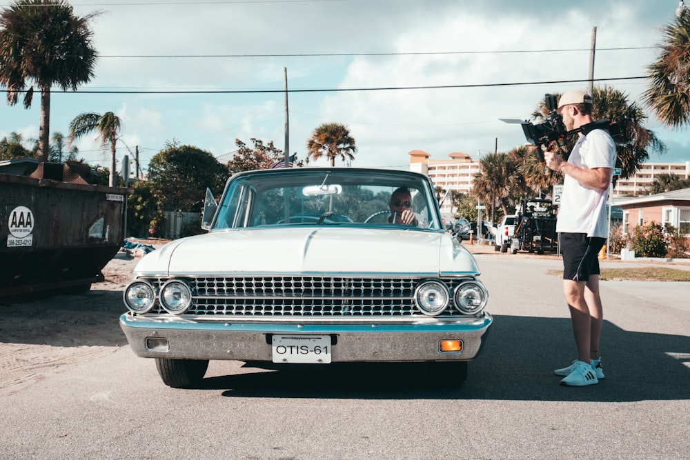 man standing beside white vehicle