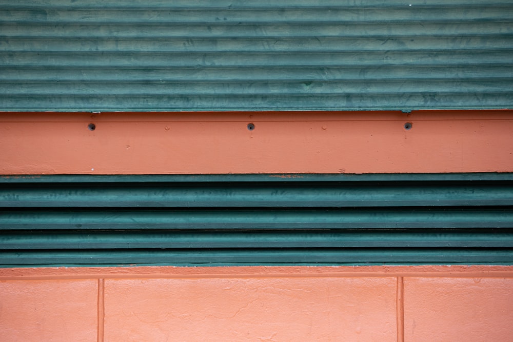 a red fire hydrant sitting in front of a green building