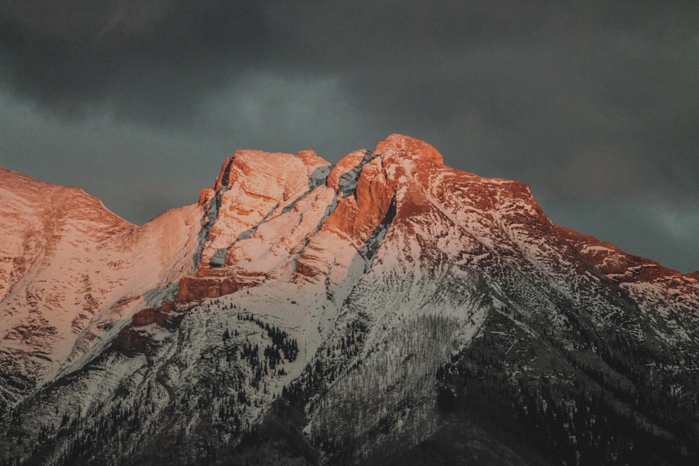 white and brown mountain under gray clouds